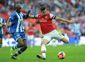 Arsenal V Wigan Athletic - FA Cup Semi Final 2014 Prints: Giroud vs. Boyce: Intense Moment at the FA Cup Semi-Final between Arsenal and Wigan