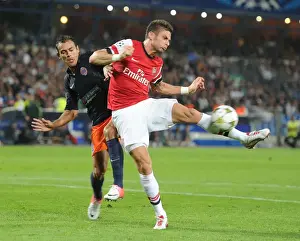 Montpellier V Arsenal 2012-13 Prints: Giroud vs Hilton: Intense Battle in Montpellier v Arsenal UEFA Champions League Clash