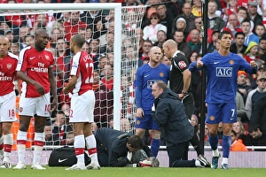 Injured Arsenal goalkeeper Manuel Almunia is treated