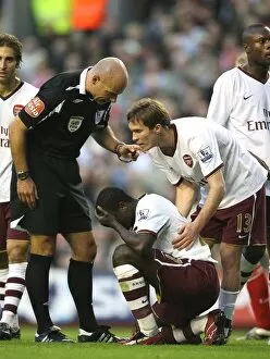 Liverpool v Arsenal 2007-8 Collection: Injured Emmanuel Eboue is helped by Arsenal team mate Alex Hleb