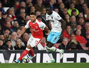 Arsenal V West Ham United 2016-17 Prints: Intense Battle: Oxlade-Chamberlain vs. Kouyate in Arsenal's Premier League Showdown