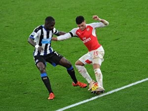 Arsenal v Newcastle United 2015-16 Collection: Intense Clash: Oxlade-Chamberlain vs. Sissoko in Arsenal's Battle Against Newcastle