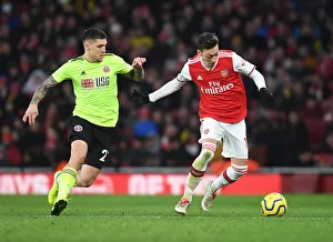 Intense Clash: Ozil vs. Baldock in Arsenal vs. Sheffield United Premier League Showdown