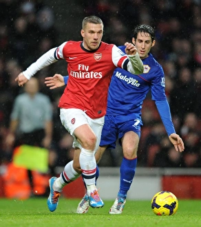 Arsenal V Cardiff City 2013-14 Prints: Intense Face-Off: Podolski vs