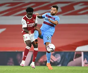Intense Premier League Clash: Arsenal's Bukayo Saka Fouls West Ham's Ryan Fredericks