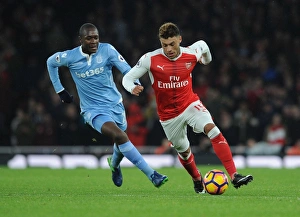 Intense Showdown: Oxlade-Chamberlain vs. Imbula in Arsenal vs. Stoke Football Clash