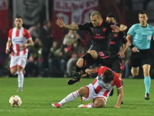 Jack Wilshere Leaps Over Filip Stojkovic in Europa League Clash between Crvena Zvezda and Arsenal