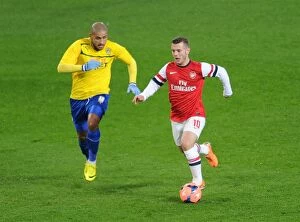 Images Dated 24th January 2014: Jack Wilshere Outpaces Leon Clarke in FA Cup Fourth Round Clash between Arsenal and Coventry City