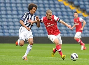 Images Dated 1st October 2012: Jack Wilshere vs. Isiah Brown: Clash of the Young Talents in Arsenal U21 vs