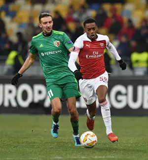 FC Vorskla Poltava V Arsenal 2018-19 Prints: Joe Willock vs. Vyacheslav Sharpar: Intense Clash in Arsenal's Europa League Battle against Vorskla Poltava