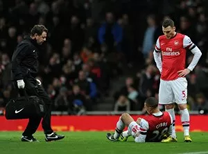 Images Dated 30th January 2013: Kieran Gibbs (Arsenal) lies injured on the floor as Physio Colon Lewin races to help him
