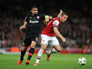 Arsenal V Olympiacos 2012-13 Prints: Lukas Podolski (Arsenal) Giannis Maniatis (Olympiacos). Arsenal 3: 1 Olympiacos