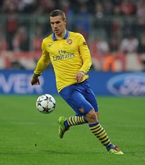 Images Dated 11th March 2014: Lukas Podolski: Battle at the Allianz Arena - FC Bayern Munich vs Arsenal
