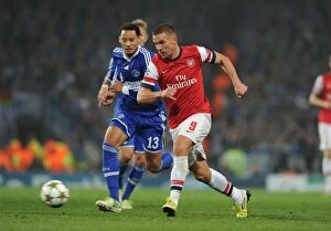 Images Dated 24th October 2012: Lukas Podolski Outmaneuvers Jermaine Jones in Arsenal's UEFA Champions League Clash