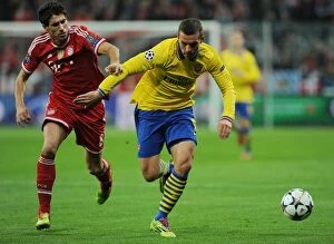 Images Dated 11th March 2014: Lukas Podolski vs. Javi Martinez: Battle in the UEFA Champions League between FC Bayern Munich