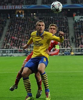Images Dated 11th March 2014: Lukas Podolski vs. Philippe Lahm: A Battle in the UEFA Champions League Round of 16