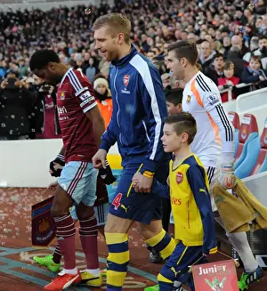 Per Mertesacker (Arsenal) with the mascot. West Ham United 1: 2 Arsenal. Barclays Premier League