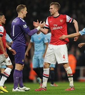 Images Dated 29th March 2014: Mertesacker and Hart Share a Moment After Arsenal vs. Manchester City Clash