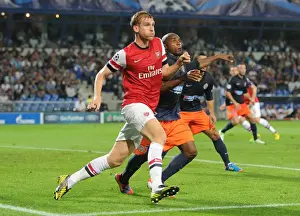 Montpellier V Arsenal 2012-13 Prints: Per Mertesacker vs. Suleyman Camara: A Battle in the UEFA Champions League (Montpellier v Arsenal 2012-13)