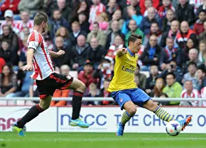 Mesut Ozil (Arsenal) passes for Arsenals 1st goal under pressure from Valentin Roberge