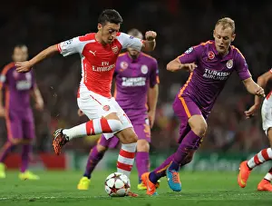 Arsenal V Galatasaray 2014/15 Champions League Prints: Mesut Ozil Breaks Past Galatasaray's Samih Kaya in Arsenal's 2014/15 Champions League Clash