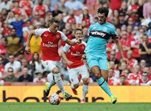 Images Dated 9th August 2015: Mesut Ozil Breaks Past West Ham's James Tomkins at Arsenal's Emirates Stadium