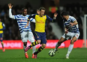 Queens Park Rangers V Arsenal 2014-15 Prints: Mesut Ozil Clashes with Junior Hoilett and Steven Caulker during Queens Park Rangers vs Arsenal Premier League Match