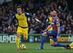 Images Dated 21st February 2015: Mesut Ozil Dodges Past Damien Delaney: Crystal Palace vs Arsenal, Premier League 2014-15