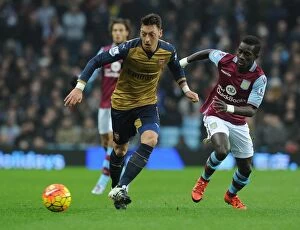 Aston Villa v Arsenal 2015-16 Collection: Mesut Ozil Faces Intense Pressure from Idrissa Gana: Aston Villa vs Arsenal, Premier League 2015-16