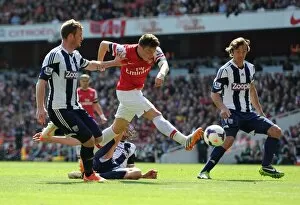 Images Dated 4th May 2014: Mesut Ozil Faces Off Against Chris Brunt and Diego Lugano: Arsenal vs West Bromwich Albion