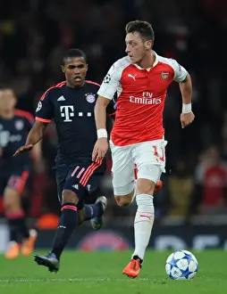 Arsenal V Bayern Munich 2015/16 Prints: Mesut Ozil Outmaneuvers Douglas Costa: Arsenal FC vs