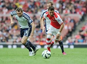 Arsenal v West Bromwich Albion 2014/15 Collection: Mesut Ozil Outmaneuvers Gareth McAuley: Arsenal's Thrilling Victory over West Bromwich Albion