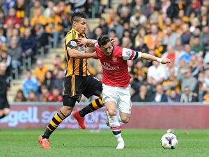Images Dated 20th April 2014: Mesut Ozil Outpaces Jake Livermore: Arsenal's Midfield Maestro Outruns Hull City Defender in