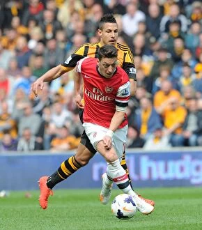 Images Dated 20th April 2014: Mesut Ozil Outpaces Jake Livermore: Arsenal's Midfield Maestro Outruns Hull City Defender