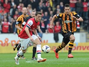 Images Dated 20th April 2014: Mesut Ozil Outpaces Jake Livermore: Arsenal's Agile Midfielder Outruns Hull City Defender