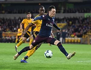 Images Dated 24th April 2019: Mesut Ozil Under Pressure: Willy Boly Closes In during Wolverhampton Wanderers vs