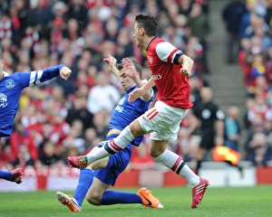 Images Dated 8th March 2014: Mesut Ozil score Arsenals 1st goal past Seamus Coleman (Everton). Arsenal 4: 1 Everton