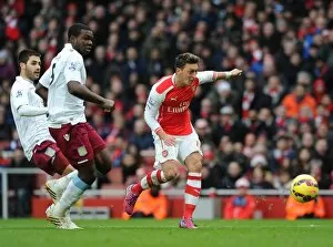 Images Dated 1st February 2015: Mesut Ozil scores Arsenals 2nd goal under pressure from Jores Okore and Carles Gil (Villa)