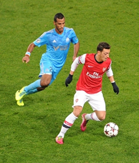 Arsenal V Marseille 2013-14 Prints: Mesut Ozil vs Alaixys Romao: A Football Rivalry Ignites in the Arsenal vs Marseille UEFA Champions League Clash