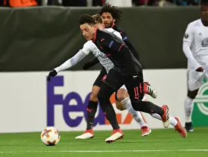 Ostersunds V Arsenal 2017-18 Prints: Mesut Ozil vs Dennis Widgren: A Battle of Midfield Maestros in Arsenal's Europa League Clash against Ostersunds FK