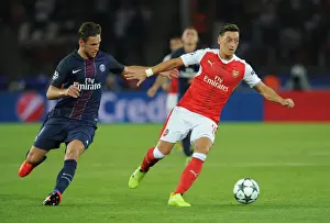 Paris Saint Gernain V Arsenal 2016-17 Prints: Mesut Ozil vs. Grzegorz Krychowiak: A Champions League Battle at Parc des Princes, 2016