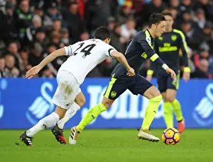 Swansea City V Arsenal - 2016-17 Prints: Mesut Ozil vs Jack Cork: A Premier League Battle at Swansea City