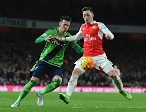 Arsenal V Southampton 2015-16 Prints: Mesut Ozil vs Jose Fonte: A Battle of Skills in the Arsenal vs Southampton Premier League Clash