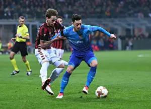 AC Milan V Arsenal 2017-18 Prints: Mesut Ozil vs. Lucas Biglia: Battle in the Europa League - Arsenal vs. AC Milan