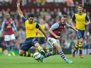 Aston Villa V Arsenal 2014-15 Prints: Mikel Arteta vs Tom Cleverly: Intense Clash in Aston Villa vs Arsenal Premier League Match