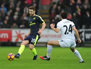 Swansea City V Arsenal - 2016-17 Prints: Mustafi vs Cork: Intense Battle in Swansea City vs Arsenal Premier League Clash