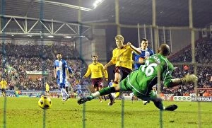 Images Dated 29th December 2010: Nicklas Bendtner shoots past Wigan goalkeeper Ali Al Habsi to score the 2nd Arsenal goal