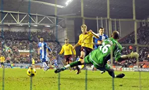 Nicklas Bendtner shoots past Wigan goalkeeper Ali Al Habsi to score the 2nd Arsenal goal