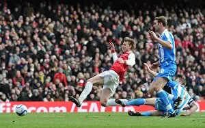 Nicklas Bendtner is tripped by Huddersfield defender Jamie McCombe for thre Arsenal penalty