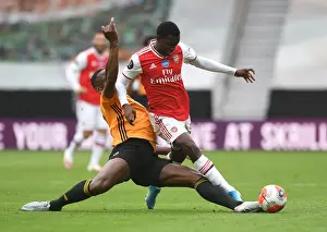 Wolverhampton Wanderers V Arsenal 2019-20 Prints: Nketiah vs. Boly: A Tense Battle in Wolverhampton Wanderers vs